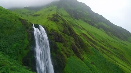 Waterfall cascading down mossy green mountainside