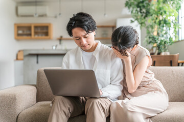 Fototapeta premium パソコンを見ながらショックを受ける夫婦・カップル（詐欺・投資・失敗・騙される） 
