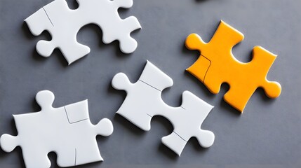 Obraz premium White and Orange Jigsaw Puzzle Pieces on Gray Background