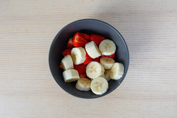 A bowl of cut strawberries and banana.