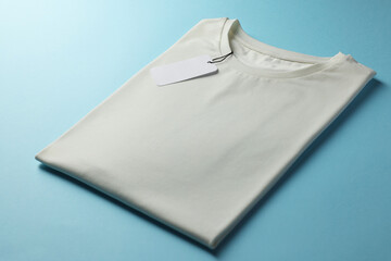 One blank t-shirt on light blue background, closeup. Mockup for design