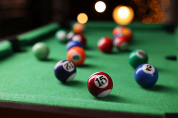 Many colorful billiard balls on green table indoors, closeup