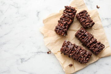 Delicious chocolate puffed rice bars on white marble table, top view. Space for text