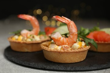Tartlets with delicious fillings on grey table, closeup. Bokeh effect