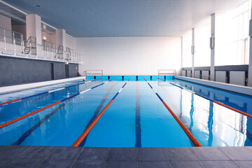 Swimming pool with clean water and lane dividers indoors