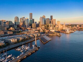 Obraz premium Seattle skyline at sunrise, waterfront docks, and boats. Aerial view of city, harbor, and marina, Seattle, Washington, USA
