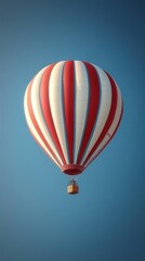 Fototapeta premium Red-white striped hot air balloon ascends clear blue sky