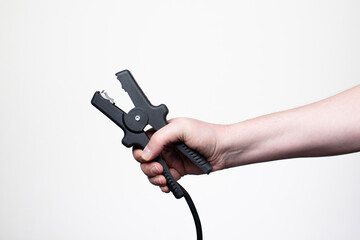 Hand of a man gripping jumper cables, isolated on a white background. Studio lighting, faceless composition, and room for text.
