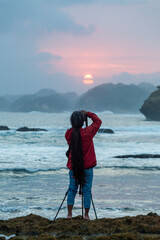 Photographer on the beach at sunset in Java Indonesia Ngliyep beach