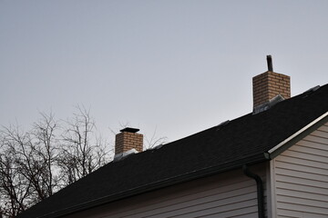 Two brick chimneys on home. Different modern inserts on each.