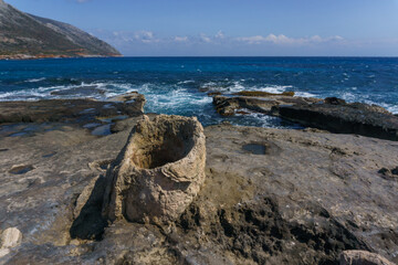 Petrified tree trunk at beautiful landscape of Geopark of Agios Nikolaos Petrified Forest at mediterranean sea coast, Laconia, Peloponnese, Greece