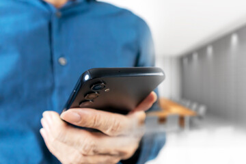 Businessman using mobile phone to read messages and touch the mobile screen to work through mobile phone.