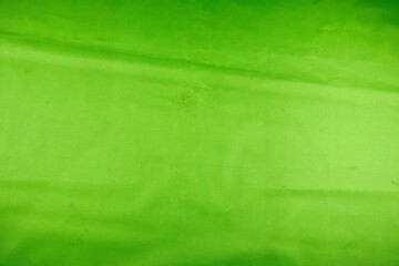 Three gold foil balloons shaped as the number 100 are displayed against a vibrant, solid lime green backdrop
 - Powered by Adobe