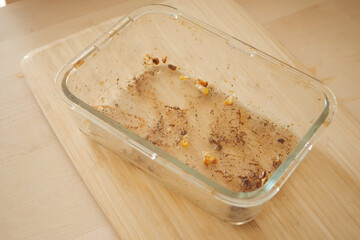 Leftover container showing traces of vegetables and spices after meal