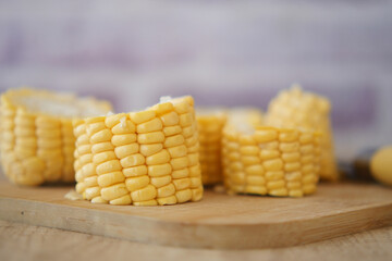 Freshly cut corn cobs arranged on a wooden cutting board