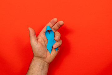 Support for cancer awareness through symbolic blue ribbon and hand gesture