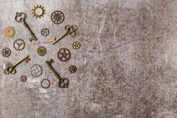 Collection of decorative aged keys with gears on dark background. Flat lay, top view. Copy space