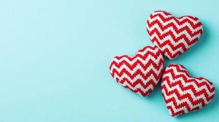 Obraz premium Two knit hearts placed on a blue background showcasing handmade textile art and love symbolism