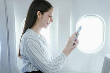 A businesswoman sits by the airplane window. She enjoys a luxurious travel experience that symbolizes success, adventure, and the excitement of traveling to new destinations.