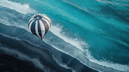 Obraz premium Hot air balloon over black sand beach, ocean waves. Travel, adventure