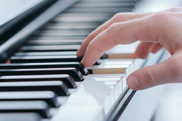 Fototapeta premium A close-up of a hand playing a piano, focusing on the black and white keys, illustrating the art of music creation.