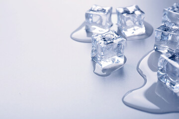 Melting ice cubes and water drops on light blue background, closeup. Space for text