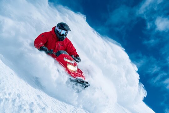 A snowmobile outrunning an avalanche on a treacherous mountain slope