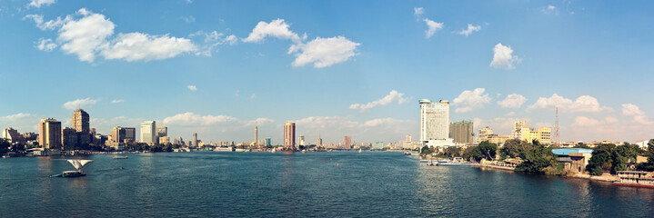Traditional wooden sailing boat with a single sail called "Felucca" sailing on the Nile River. Cairo, Egypt
