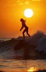 Silhouette of woman surfer riding waves on surfboard during orange sunset. People water sport lessons beach activity on summer vacation. Female silhouette enjoys summer vacation on surfboard against
