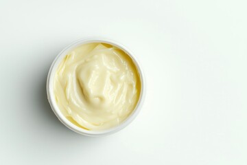 Minimalist shot of nourishing butter for skin in a container on an immaculate white surface