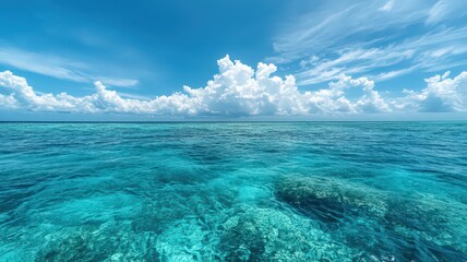 Tranquil Turquoise Ocean Scene with Shallow Coral Reef and Bright Sky