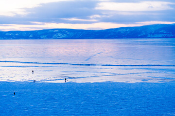 Tourists walk on a frozen river in Baikal, Irkutsk Oblast, Russia.