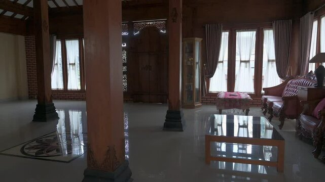 Classic interior design of Indonesian traditional wooden house, slow panning left to right showing classic wooden furniture