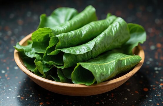 Indian Gujarati Patra made from colocasia leaves, also known as arbi or taro leaves on wooden plate. Traditional vegetarian recipe for healthy meal, curry or lunch. Fresh farm plant.