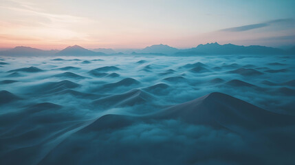 Aerial view of misty desert dunes at sunrise, mountains in background; ideal for travel or environmental themes