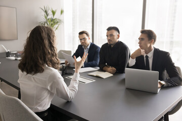 Unfair barrier. Back view young lady business professional compete for opening for her dream job but feel pressure bias prejudice on interview with male recruiters team having gender based stereotypes