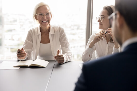 Laughter in professional communication. Joyful senior female team leader ceo employee express funny idea on staff meeting at boardroom feel happy of business success having fun moment at conversation