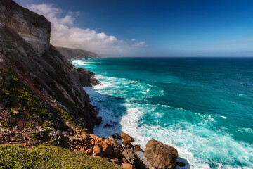 Obraz premium Coastal Cliff with Waterfall and Clear Blue Ocean