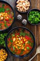 Fresh vegetable soup with chickpea on wooden table
