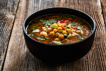 Fresh vegetable soup with chickpea on wooden table
