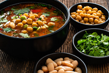 Fresh vegetable soup with chickpea on wooden table
