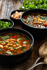 Fresh vegetable soup with chickpea on wooden table
