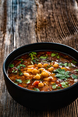 Fresh vegetable soup with chickpea on wooden table
