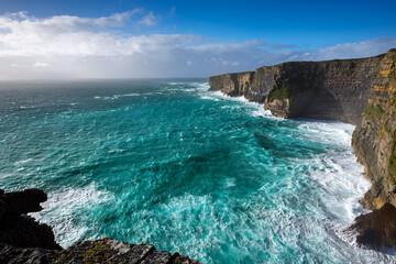 Coastal Cliff with Waterfall and Clear Blue Ocean