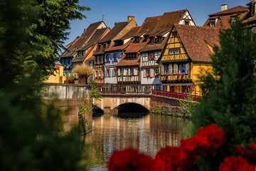 Fototapeta premium Ornate traditional half timbered houses with blooming flowers along the canals, Little Venice district in Colmar, picturesque village in Alsace France