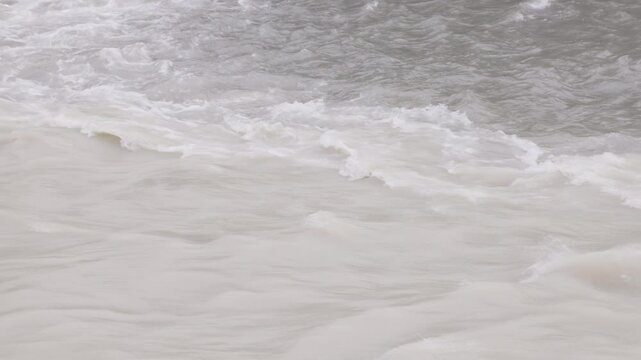 muddy seething water in slow motion with visible boundary where two contrasting flows mix and collide., closeup full-frame background