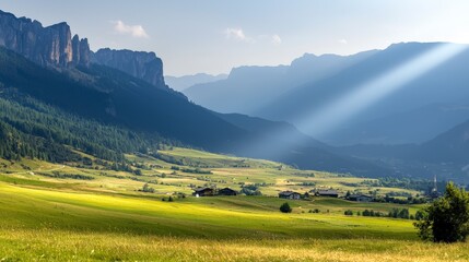 Serene Mountain Landscape with Lush Green Valley Under Dramatic Sky and Sunbeam