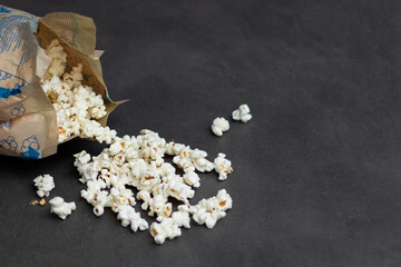 Fresh popcorn in bag made in a microwave on grey kitchen table
