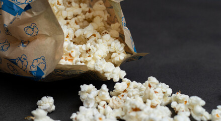 Fresh popcorn in bag made in a microwave on grey kitchen table