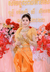 Cambodian bride in golden Khmer traditional dress posing at a wedding ceremony in Phnom Penh.
